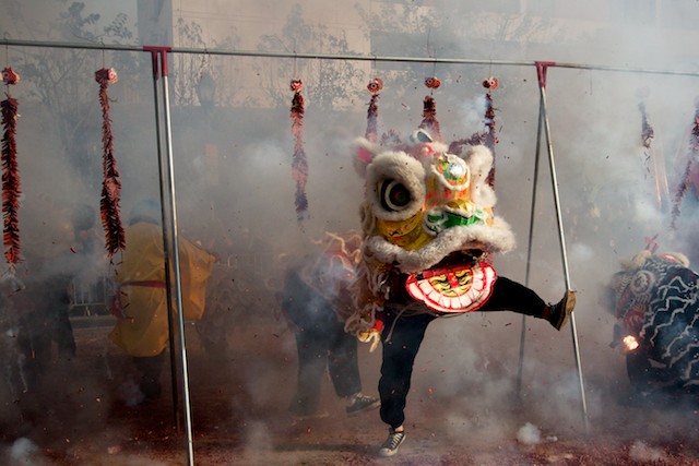 A Chinese lion dances through firecrackers in an attempt to ward off evil during the 2011 Golden Dragon Chinese New Year Parade.