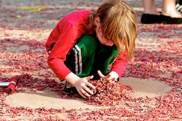 A child collects the paper casings of spent firecrackers after the closing ceremony of the 2011 Golden Dragon Chinese New Year Parade.
