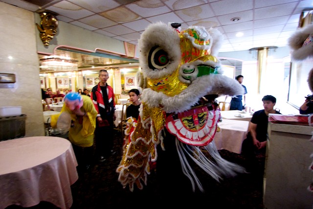 A Chinese lion leaves a restaurant in Chinatown after chasing away evil spirits.